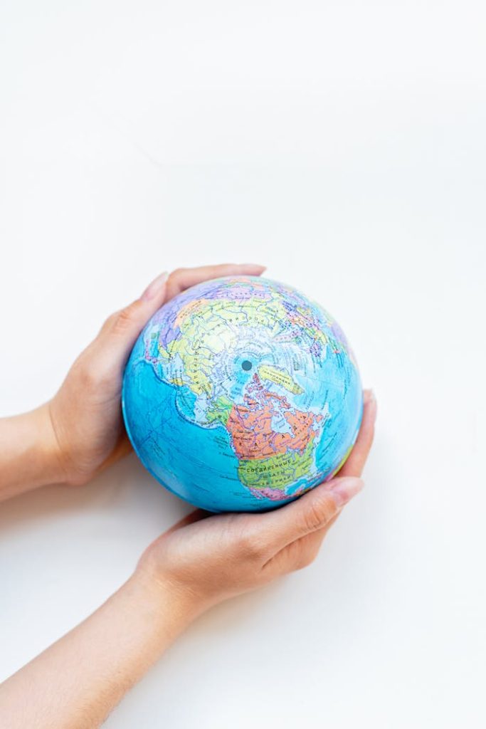 The Art of Drawing Readers In: Your attractive post title goes here A close-up of hands gently holding a colorful globe against a white background.